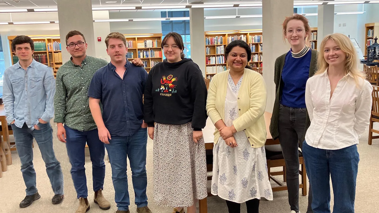Group of 7 MSSI participants smiling and facing camera in the Special Collections Reading Room of Thompson Library